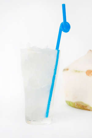 fresh coconut juice in a tall glass with coconut backgroundの写真素材