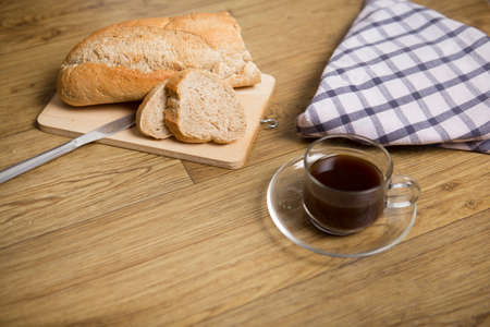 a cup of black coffee french bread and napkin on a wood backgroundの写真素材