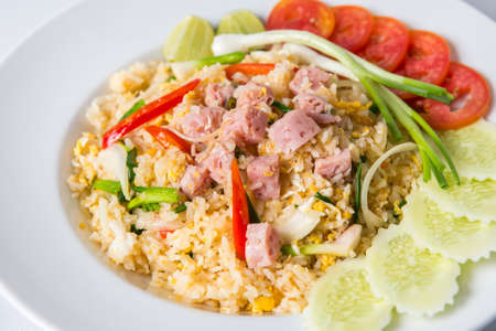 thai fired rice with sour pork decorated with sliced cucumber and tomatoの写真素材