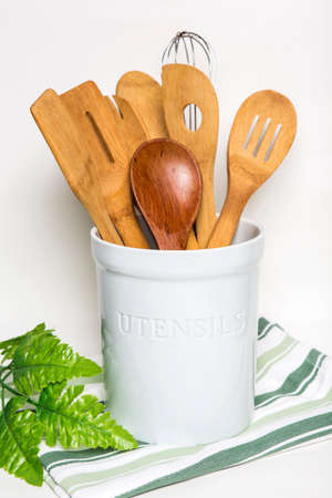 Bangkok, Thailand April 21,2020 Kitchen wooden utensils in ceramic holder put on green stripped cloth. isolated on white backgroundのeditorial素材
