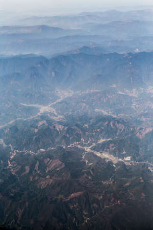 Bangkok, Thailand- Feb 20,2014 : mountain view covered by some snow with blue sky and fog from airplane window sideの写真素材