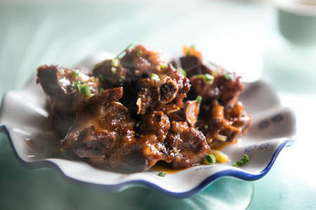 stir fried chopped pork ribs, chinese style food serve in small white ceramic wave shaped plateの写真素材