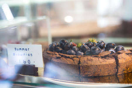 SamutPrakan,Thailand - July 8, 2020 : side view closeup of chocolate brownies cakes top with blueberries put in a showcase with price tag showingのeditorial素材