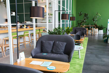 Bangkok, Thailand - August 7, 2020: trendy modern contemporary green and wooden living space decorated with black 2 seat sofas and standing lampsのeditorial素材