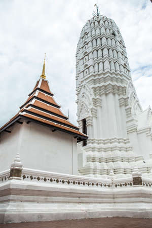 white traditional thai pagoda next to thai style chapelの写真素材