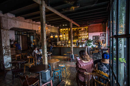 Bangkok, Thailand - 30 Sep 2020: exquisite modern rustic and vintage interior cafe and restaurant old wooden tables and chairs while few people are sittingのeditorial素材