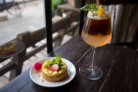 Lemon tart with fresh strawberry and soda serve on dark wooden tableの写真素材