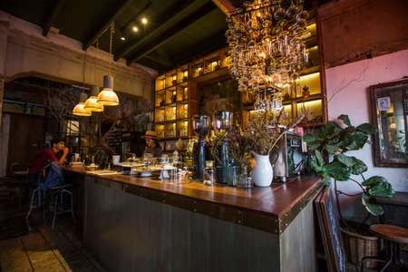 Bangkok, Thailand - 30 Sep 2020: industrial counter bar with decoration of hanging glasses and vase and warming light big shelfのeditorial素材