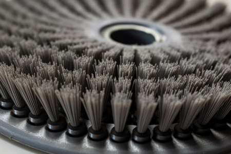 A new industrial scrubber brush head with bristles arranged in a circular pattern, ready for use in cleaning large machinery, is shown up close.の素材