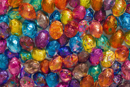 Festive Foil and Chocolate: A Symphony of Colorful Easter Egg Wrappers Catching the Morning Lightの素材