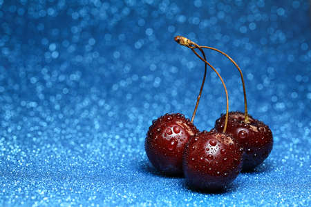 sweet cherry with drops of water on a bokeh background
