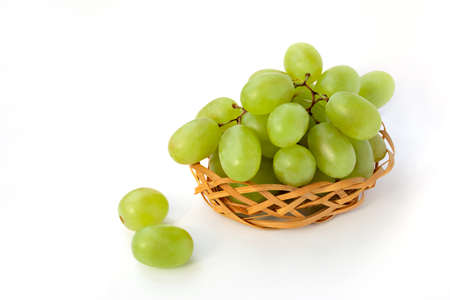 green grapes in a basket on a white backgroundの写真素材