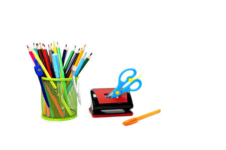 stationery school items. colored pencils with hole punch and scissors on white isolated backgroundの写真素材