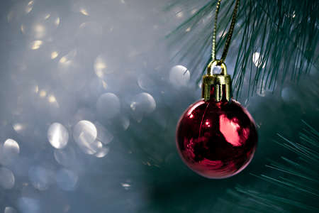 branch of a Christmas tree with a red ball on a yellow background withの写真素材