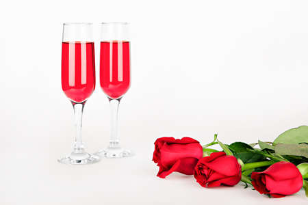 holiday card two glasses with red wine and red rosesの写真素材