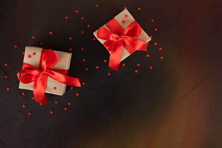 gift boxes with red ribbon and stars on black backgroundの写真素材