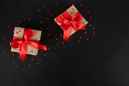 gift boxes with red ribbon and stars on black backgroundの写真素材