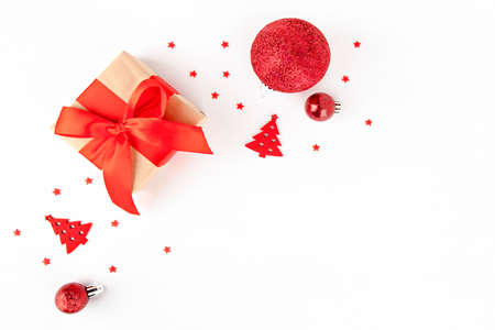 on a light background christmas card gift with red ribbon and red ornamentsの写真素材