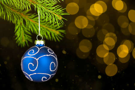 Christmas card on a black background Christmas tree branch with blue ornaments and bokehの写真素材