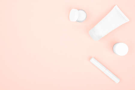 on a pink background white cosmetics, hand cream, face cream and lipstickの写真素材