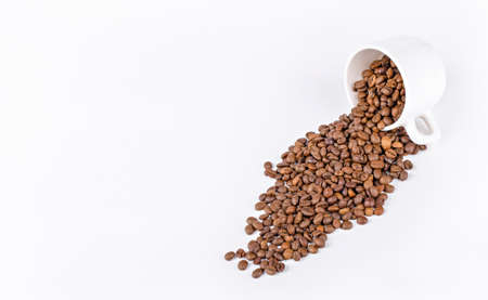 white mug with coffee beans on a light backgroundの写真素材