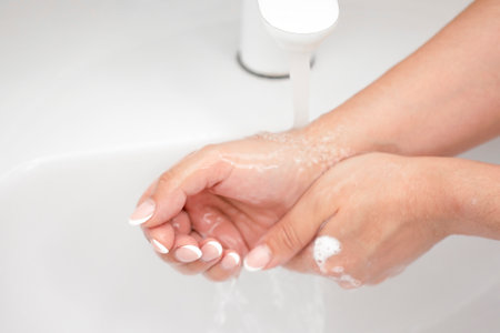 washing female hands under running waterの写真素材
