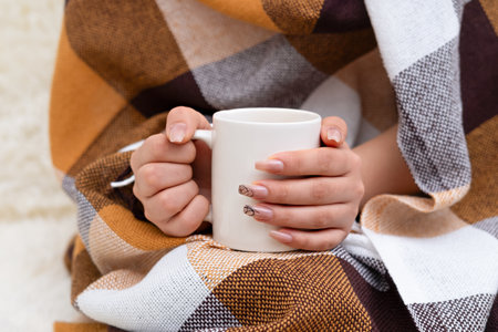 Female hands holding a white mug of coffee.の写真素材