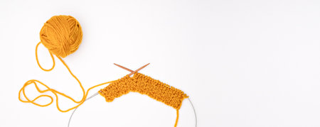 A ball of yarn with knitting needles on a light background.の写真素材