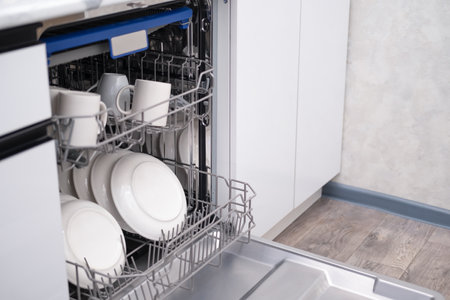 Built-in dishwasher door open. Kitchen with built-in appliances.の写真素材