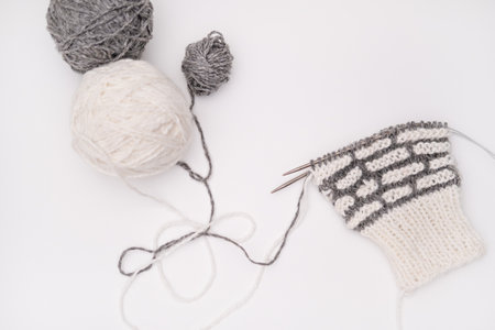 A ball of yarn with knitting needles on a light background.の写真素材