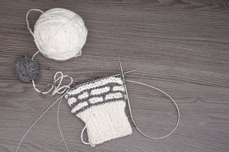 A ball of yarn with knitting needles on a light background.の写真素材