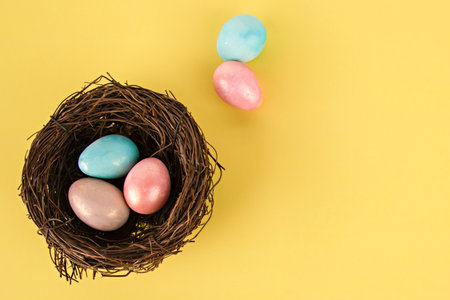 easter eggs in a nest on a yellow background.の写真素材