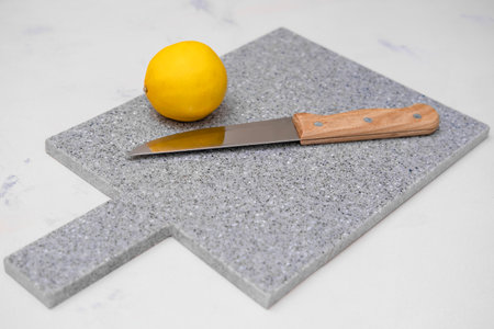 lemon on a gray board with a knife.の写真素材