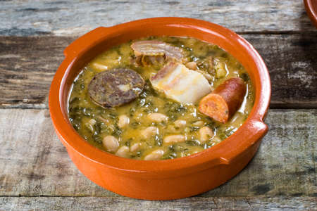 typical northern spain dish made with beans, cabbage and pork meat served in traditional clay pot.の写真素材