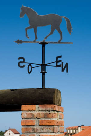 decorative wind vane with horse silhouette and letters indicating the points of the compass. Vertical compositionの写真素材
