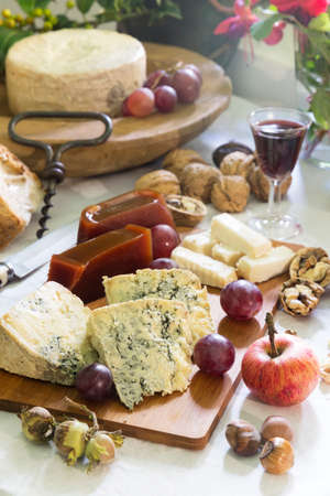 Rustic Still-life of Asturian blue cheese (cabrales) with sweet quince, nuts, hazelnuts, grapes, apple, and red wineの写真素材