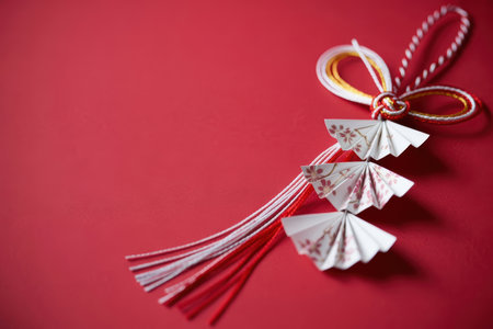 Elegant Japanese Mizuhiki Decoration on Red Backgroundの素材