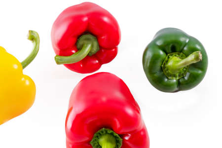 Red, green and yellow peppers. Flying peppers on a white background. Tastes in the kitchen.の写真素材