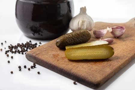 Pickled cucumbers in a stone dish.  Sliced cucumbers on a wooden board.. White background. Polish cuisine. Tastes of Europe. Healthy food.の写真素材
