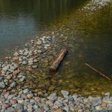 Stones in the water. The rocky shore of the pond. Resting at the lake. Holiday hiking. Europe, Poland, Mazovia.の写真素材
