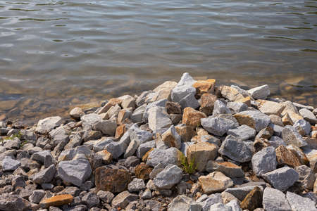 Stones in the water. The rocky shore of the pond. Resting at the lake. Holiday hiking. Europe, Poland, Mazovia.の写真素材