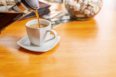 White cup of black coffee. A cup of hot drink on a wooden table. A coffee break. Relax time.