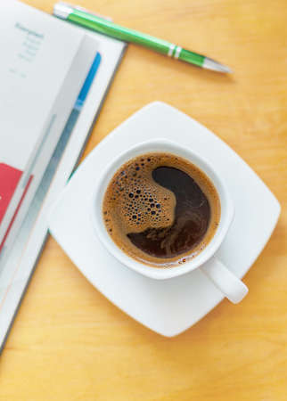 White cup of black coffee. A cup of hot drink on a wooden table. A coffee break. Relax time.の写真素材