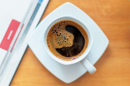 White cup of black coffee. A cup of hot drink on a wooden table. A coffee break. Relax time.の写真素材