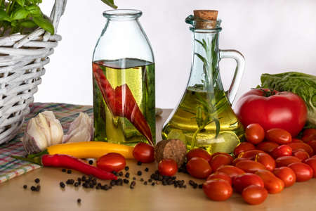 Bottles with flavored oil. Tastes of Italy. Basil, pepper and garlic. Preparing a salad.. Tomatoes and flavors of pizza.の写真素材