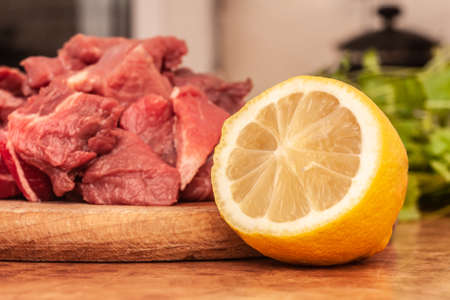 Lemon in the kitchen and raw meat for stew. Preparing dinner. Lemon as an additive.の写真素材