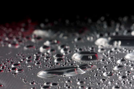 Water drops closeup. Wet background. Water theme. After rain. Red element. Black backgroundの写真素材