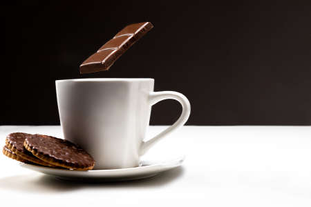 Hot chocolate with cookies. A cup and flying chocolate. Something sweet. Coffee and sweets.