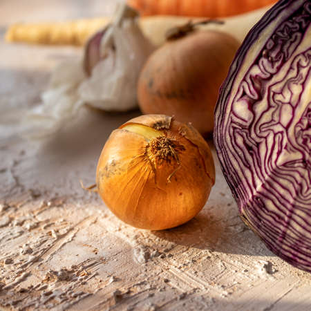 Golden onion in the light of the sun. Rustic table with vegetables. Soup products. Vegan diet. Healthy food.の写真素材
