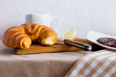 Breakfast with butter croissant and plum jam. A tasty morning. Background for restaurants. Polish...